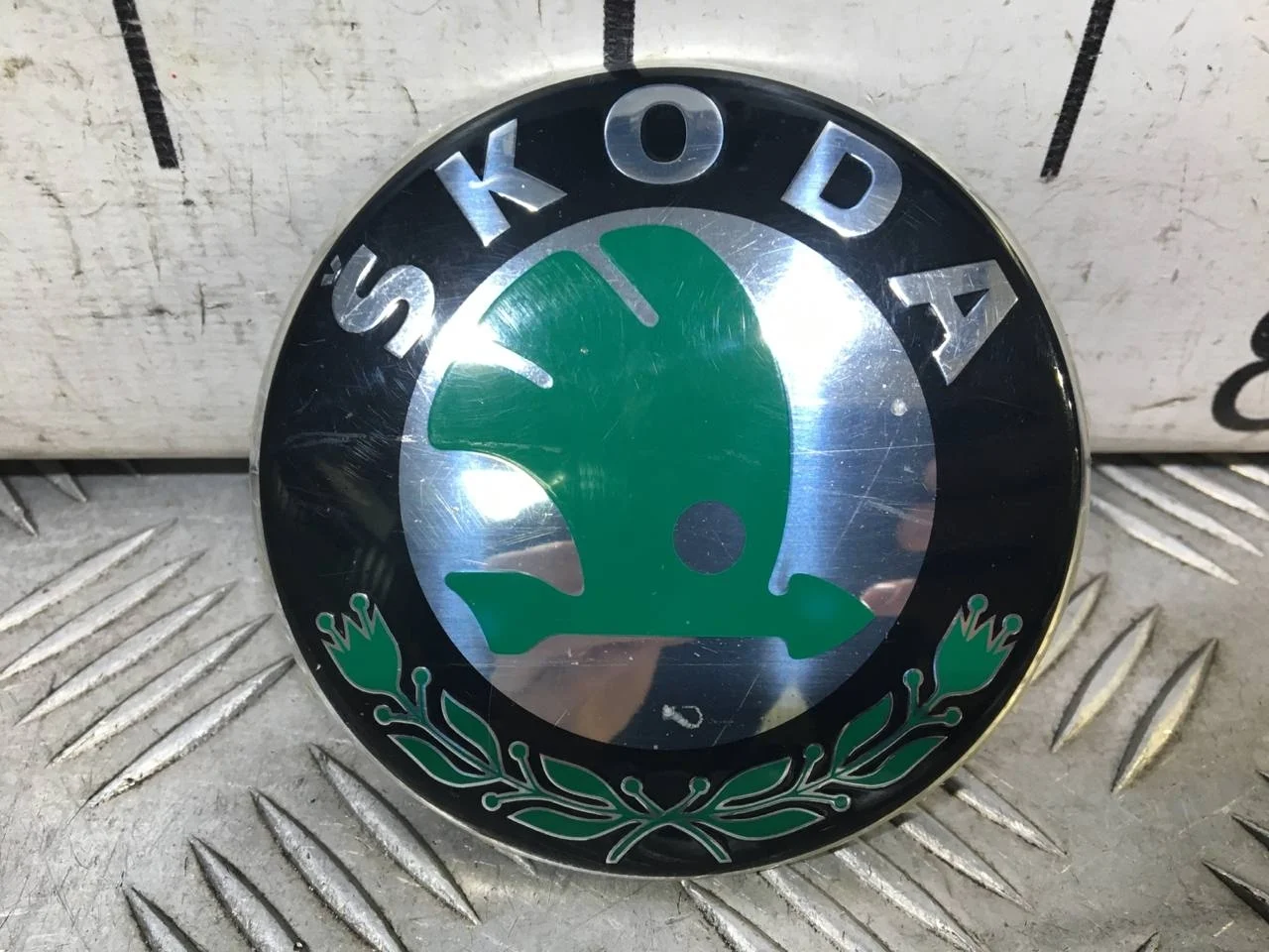 [Б/У] Эмблема SKODA передняя - (Состояние: потертости, мелкие царпины) [ХОРОШЕЕ] [Код: 00565890 ]