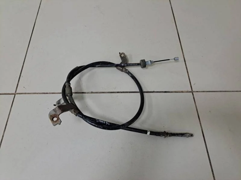 Трос стояночного тормоза левый Kia Rio 3 (UB) 2011-2017